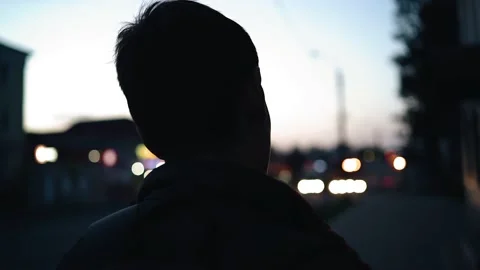 A guy with a backpack on his back walks through the night city Stock Footage 154369574