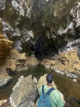 Guy with a backpack looking at Xien lap cave, Thakhek loop, Laos Stock Photos