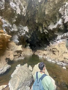 Guy with a backpack looking at Xien lap cave, Thakhek loop, Laos Stock Photos