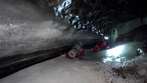 A guy with a backpack moves around an ice cave. Vídeos de archivo 234512043