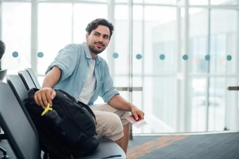 The guy with the backpack is sitting at the airport. Stock Photos