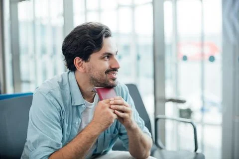 The guy with the backpack is sitting at the airport. Stock Photos