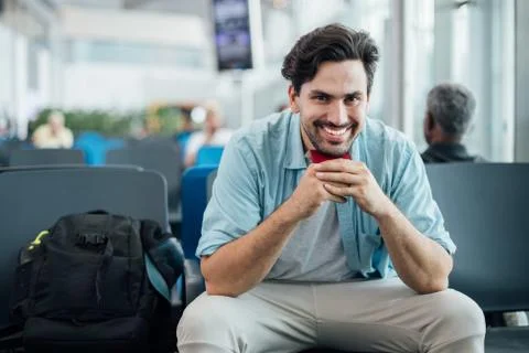 The guy with the backpack is sitting at the airport. Stock Photos