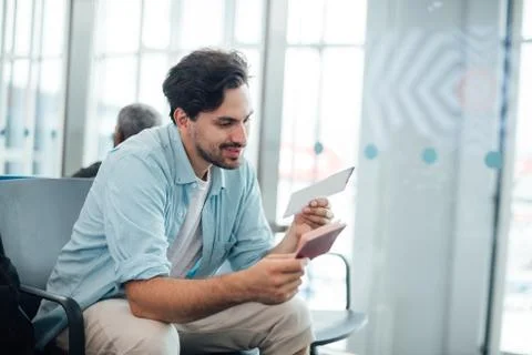 The guy with the backpack is sitting at the airport. Stock Photos