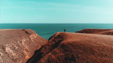 The guy with backpack stands on the mountain top against the seascape Stock-Footage 151367470