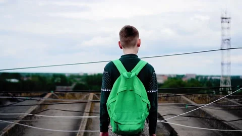 A guy with a backpack stands on the roof of a high-rise building Stock Footage 314267747