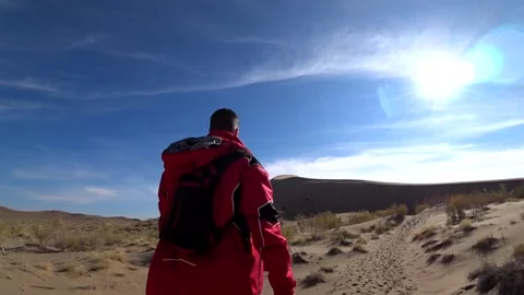 A guy with a backpack is walking in the desert. Stock Footage 161809039