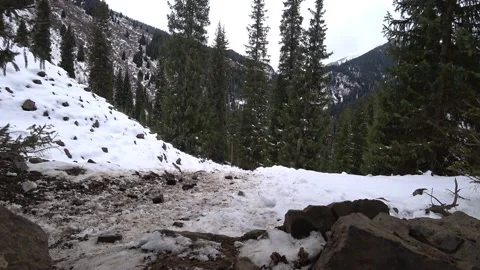 A guy with a backpack walks along a snowy trail Stock Footage 226338915