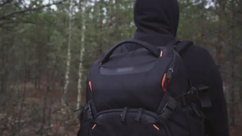 A guy with a backpack walks in the forest Stock Footage 231714392
