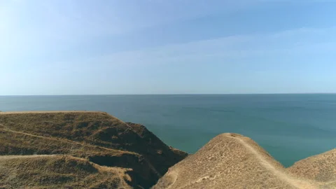 The guy with bag standing on the mountain top against the seascape Stock Footage 143042204