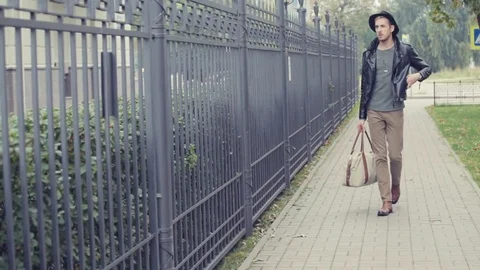 The guy with the bag walking down the street Stock Footage 80492756