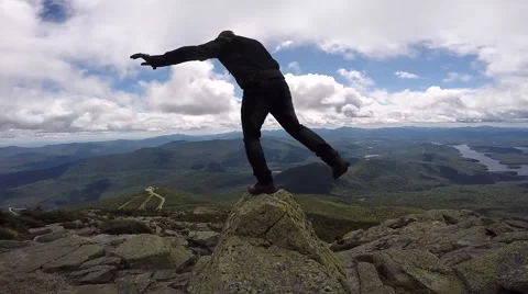 Guy balances on top of mountain Stock Footage 56564907