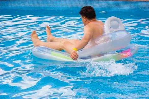 The guy is bathing on an inflatable mattress Stock Photos