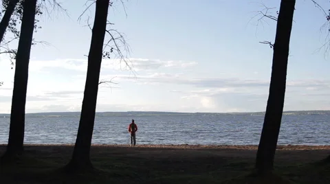 The guy is on the beach and looks afar 動画素材 65221468