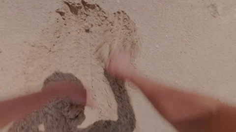 A guy on the beach digs a hole in the sand very quickly with his hands. 库存影片 339621747