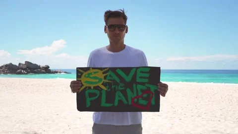 A guy on the beach with a "Save the Planet" poster Stock Footage 154668848