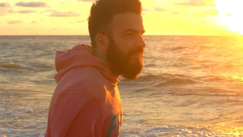 The guy with the beard admires the sea at dawn Video stock 102499027