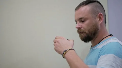 A guy with a beard and a mohawk drinking tea from a bowl Stock Footage 99573643