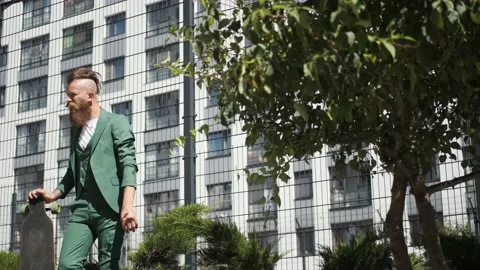 Guy with beard and mustache in green suit with longboard, concept of freedom Stock Footage 147473971