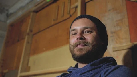 A guy with a beard and mustache in a knitted hat laughs Stock Footage 102942008