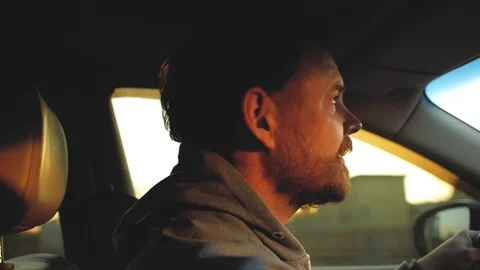 A guy with a beard with beautiful eyes is driving a car. sun rays in the wind Stock Footage 103568606