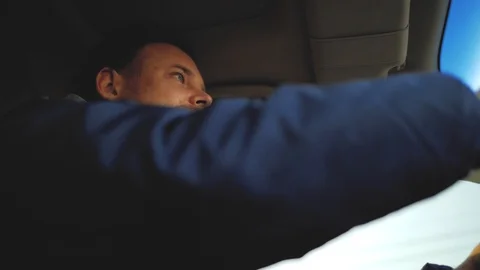 A guy with a beard with beautiful eyes is driving a car. view from below Stock Footage 103568649