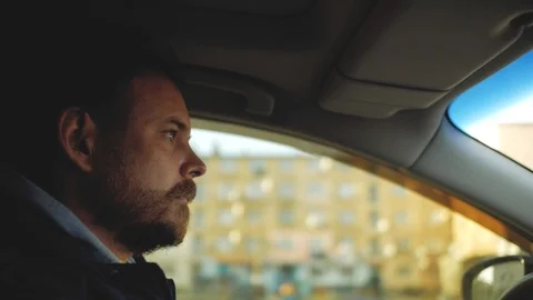 A guy with a beard with beautiful eyes is driving a car. sun rays in the wind Stock Footage 103569175