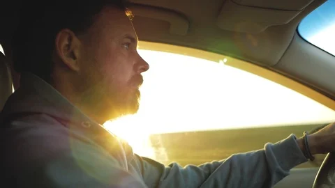 A guy with a beard gently drives a car in the sun Stock Footage 103217734
