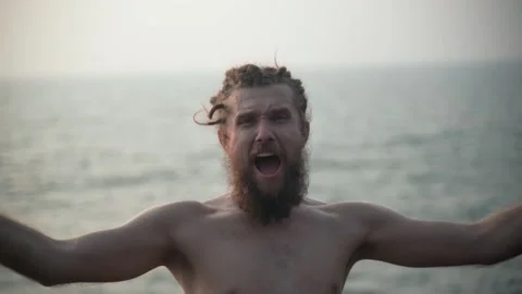 The guy with the beard looks into the camera and starts screaming emotionally. Video stock 234020084