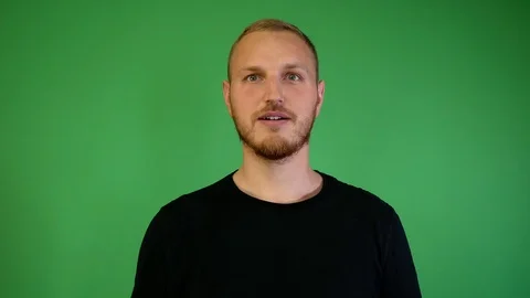 Guy with a beard marvels at the chroma key Stock Footage 115237263