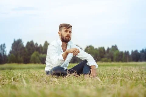 The guy with the beard sitting on the grass Stock Photos