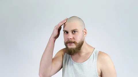 The guy with the beard touches his bald head and smiling.Short hair Stock Footage 122005545