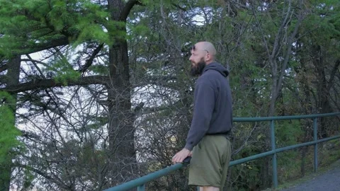 A guy with a beard walks along the path among the trees Stock Footage 219968158