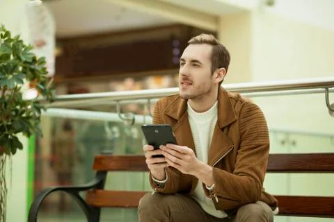 The guy on the bench with a tablet in hands Stock Photos