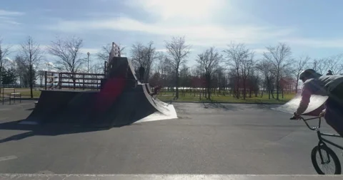 Guy on a bike performs a trick in a stunt park Video stock 102496985