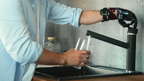 Guy with bio hand prothesis opens tap and pours water Stock Footage 157350330