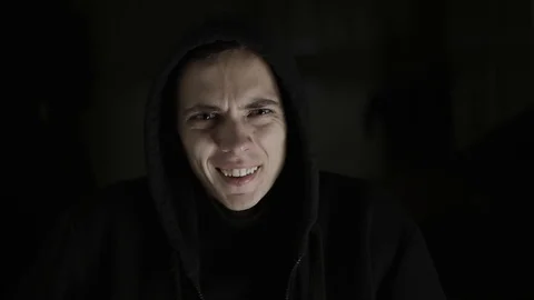 A guy with a bipolar disorder laughs and gets angry in dramatic lighting Stock Footage 120597382