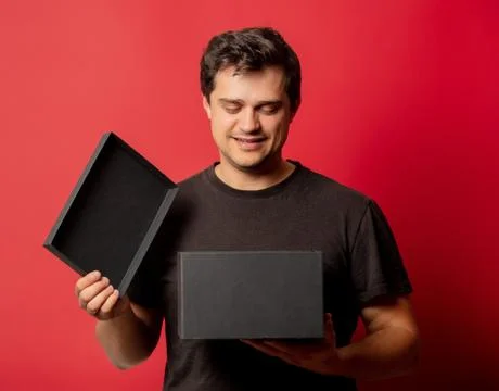 Guy with black box on red background Stock Photos