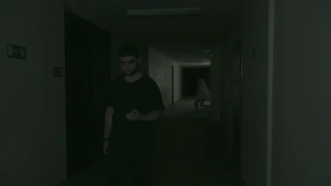 A guy in black clothes and a black velvet walks down the dark corridor 库存影片 155905129