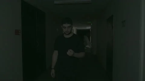 A guy in black clothes and a black velvet walks down the dark corridor 스톡 동영상 155905298