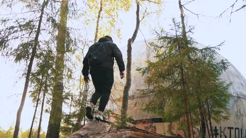 Guy in black clothes walks to large spherical object 스톡 동영상 153089739