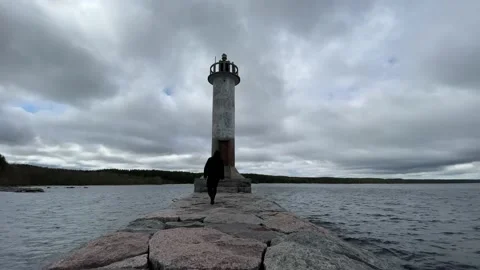 A guy in a black jacket is sad and looks into the distance next to the sea light Stock-Footage 205833014