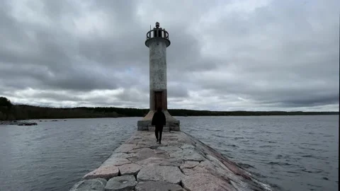 A guy in a black jacket is sad and looks into the distance next to the sea light Stock-Footage 205833036