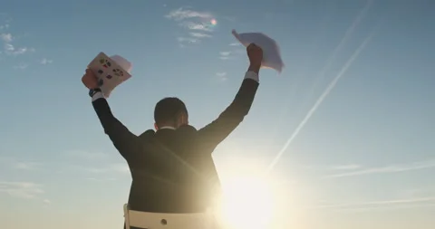Guy in black suit raises hands with sheets of papers Stock Footage 155878043