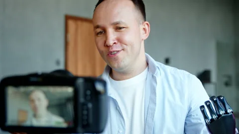 Guy blogger with bio hand prothesis conducts online stream Stock Footage 157351070