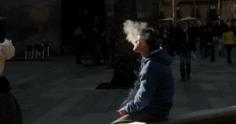 Guy Blows Out The Smoke On A Square In Barcelona Slow-Motion HD 스톡 동영상 131565915
