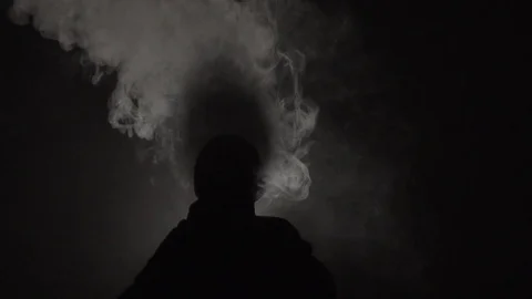 Guy blows smoke at night Stock Footage 124534274