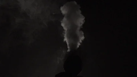 Guy blows smoke at night Stock Footage 124534301