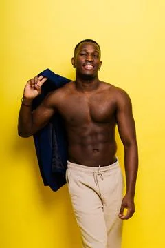 Guy in blue suit on yellow background. Handsome athletic man in jacket smiling Stock Photos