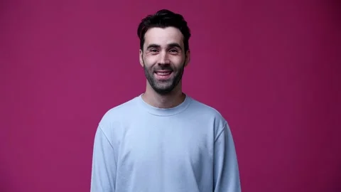 A guy in a blue sweater looks at the camera and smiles Stock Footage 162841901